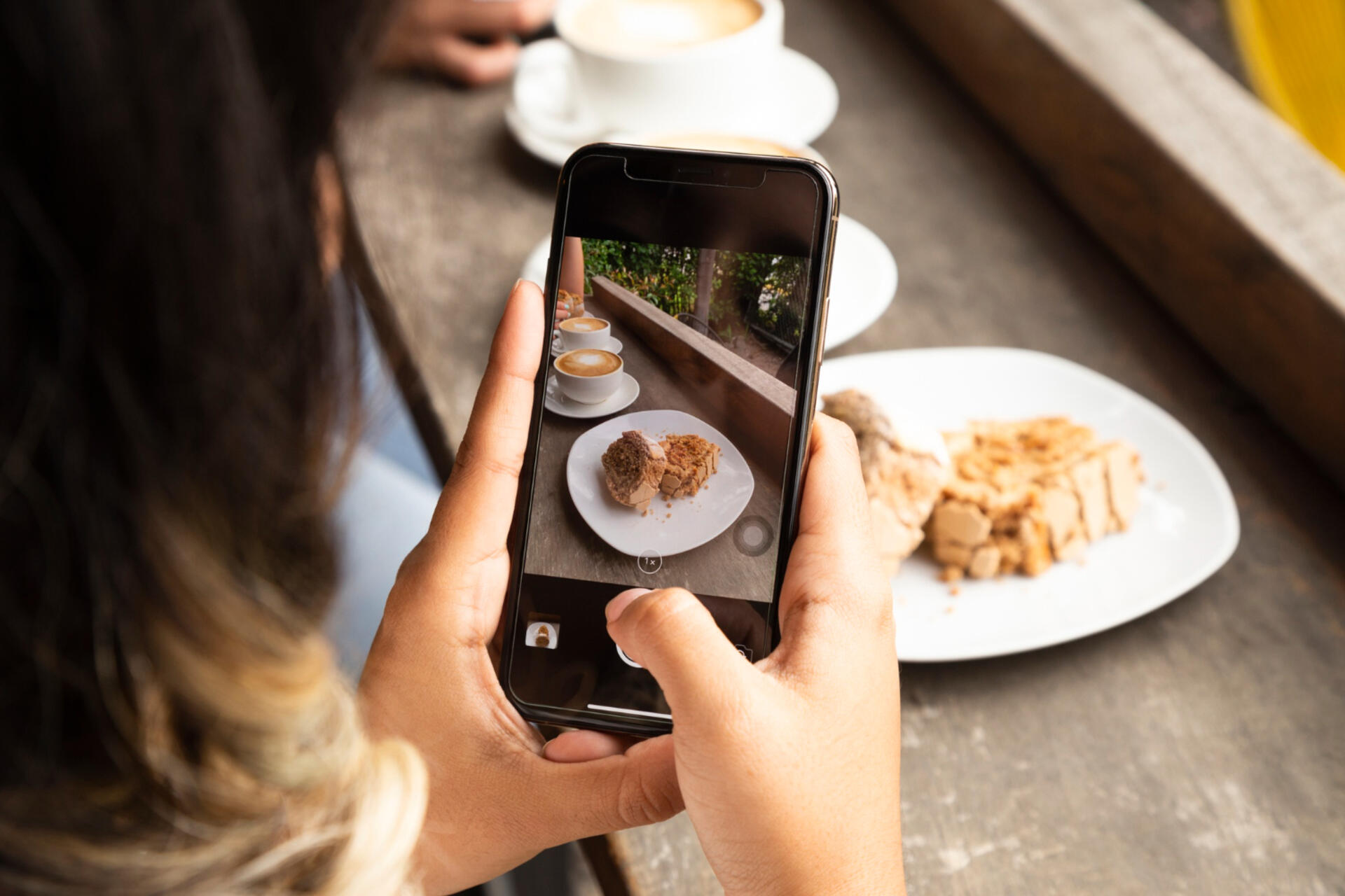 woman taking a photo of a food from her restaurant she can use to promote on social media